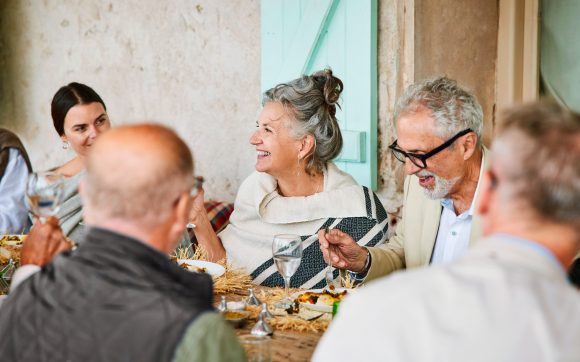 Senior couple enjoying reception dinner with friends