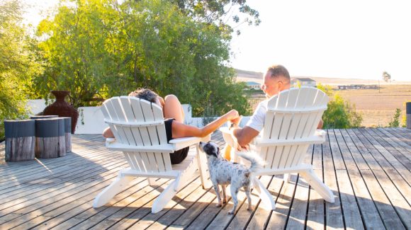 Mature couple sitting on Adirondack chairs