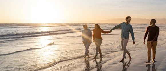 Family walking on beach at sunset