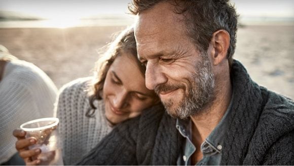 Older father smiling with adult daughter