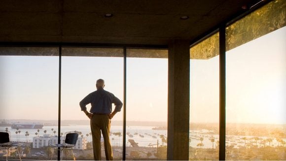 Silhouette of man gazing out office window