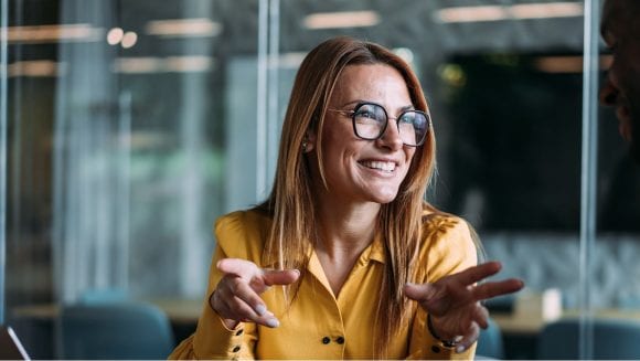 Woman in office smiling while in discussion
