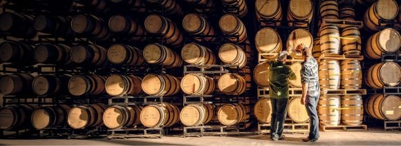 Two people barrells of wine