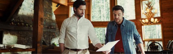 Two brothers in lake house reviewing paperwork