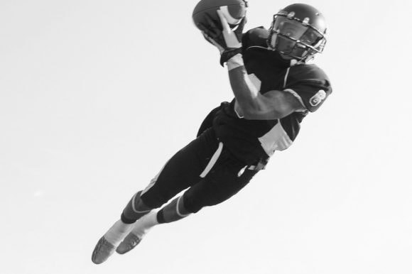 Baseball player is catching the ball high in the air