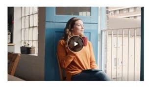 Women seating in a window with a cup of coffee