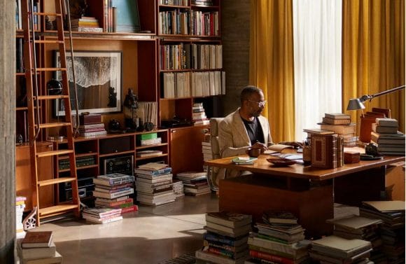 Wide-shot of man in home office and library