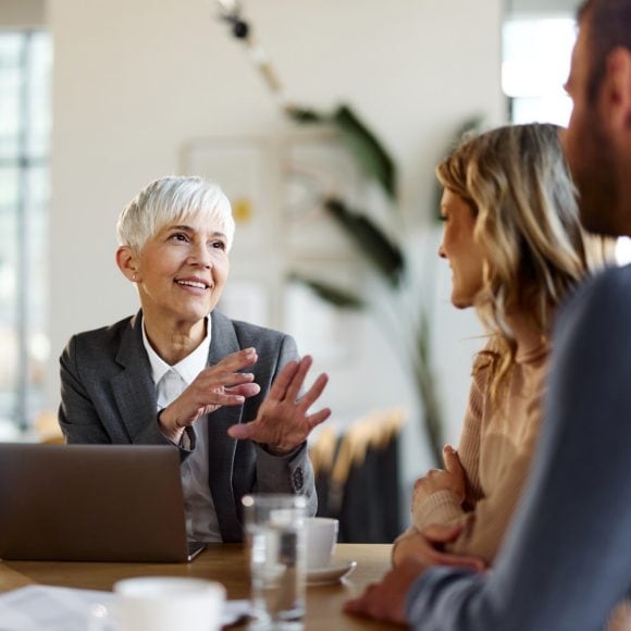 Female Financial Advisor communicating with a couple during a meeting in the office
