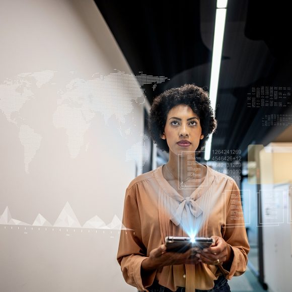Woman with tablet viewing hologram