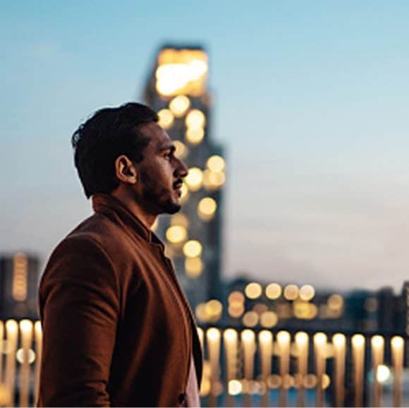 Visionary entrepreneur searching for inspiration on city rooftop at dusk
