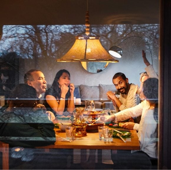 Three generations of African American family enjoying each other's company at dinner table
